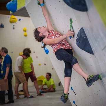 Fille en train de grimper sur un mur d'escalade