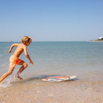 Enfant faisant du skimboard plage de La Concurrence