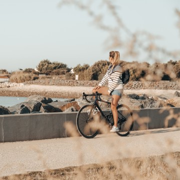 Femme à vélo à la Pointe du Chai