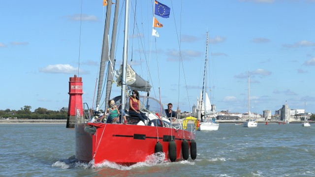 Voilier rouge sortant du chenal